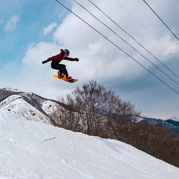 Snowboarder getting air on the hip in Hakuba 47 Park