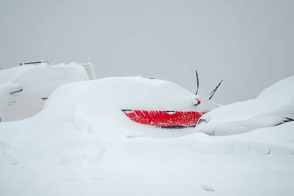 Falls Creek red car covered in snow with only door partially visible