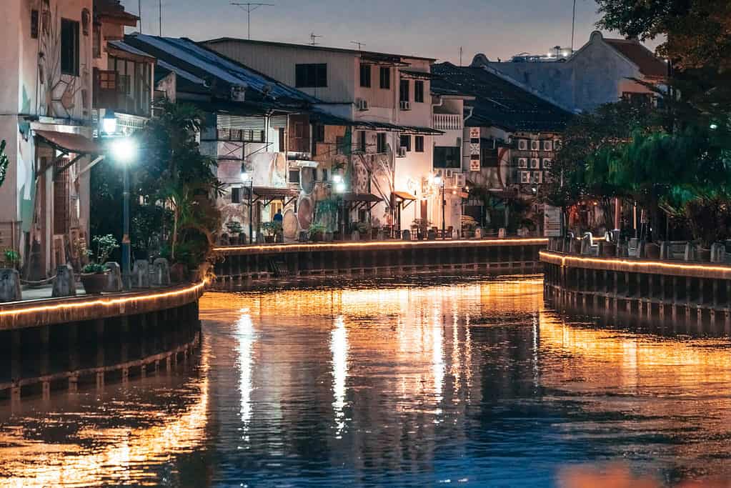 Melaka river at night with golden lights reflecting on the water