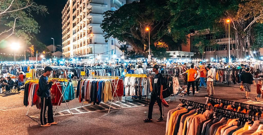 melaka vintage market at night - racks of clothing and shoppers looking at items
