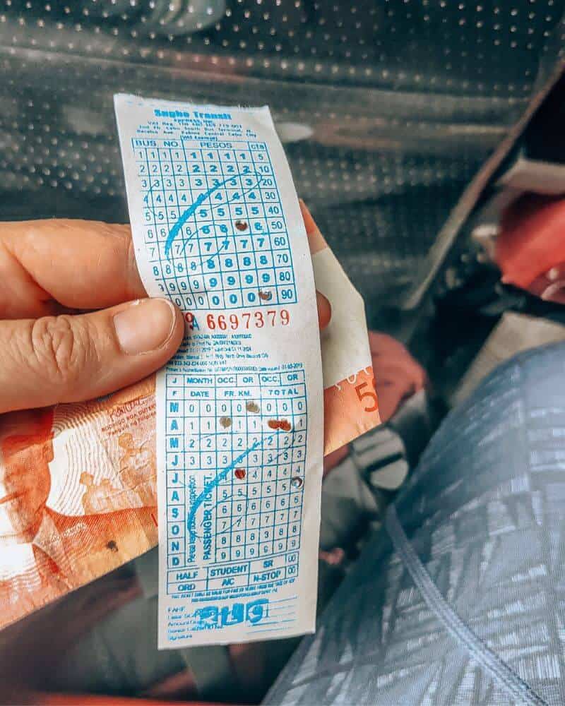 Hand holding ticket showing bus fare in the Philippines